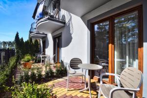 un patio con sedie e un tavolo sul balcone. di Dafne1 apartamenty a Niechorze