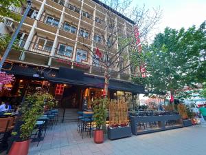 a store with tables and chairs in front of a building at HOTEL LYBETEN in Ferizaj