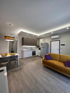 uma sala de estar com um sofá amarelo e uma cozinha em SUMMER PARADISE em Bari