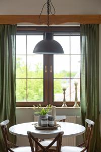 uma sala de jantar com uma mesa e uma grande janela em Apartament Wigilijna Premium Starówka em Elblag