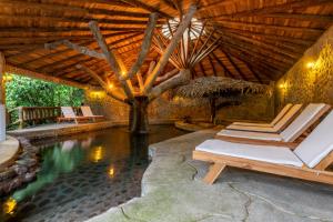 埃尔卡斯蒂约Rancho Margot Sustainable & Self Sufficient Eco Lodge的一个带躺椅的木制屋顶游泳池