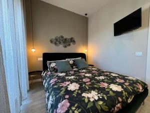 - une chambre dotée d'un lit avec un couvre-lit floral dans l'établissement SUMMER PARADISE, à Bari