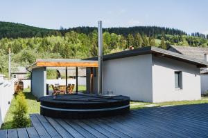 ein Haus mit einer Terrasse mit einem Tisch und Stühlen in der Unterkunft Voronet Noir Chalet in Woronetz