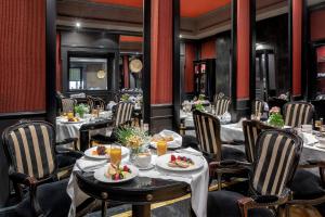 a restaurant with tables and chairs with food on them at Baglioni Hotel Regina - The Leading Hotels of the World in Rome