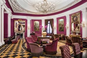 um quarto com paredes e cadeiras roxas e um lustre em Baglioni Hotel Regina - The Leading Hotels of the World em Roma