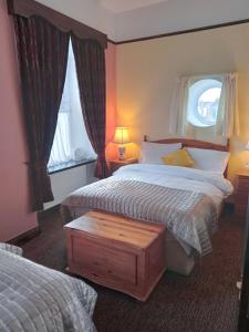 una camera d'albergo con due letti e una finestra di Buggle's Pub and Accommodation a Kilrush