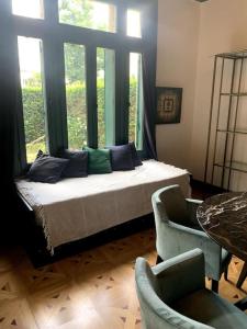 een slaapkamer met een bed en 2 stoelen en een raam bij Pavillon indépendant en plein centre de Vichy in Vichy