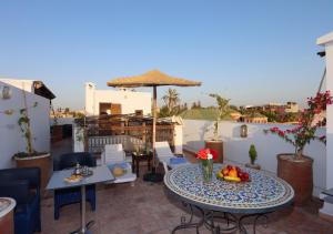 a patio with a table and chairs and an umbrella at Riad Morocco Sky in Marrakech