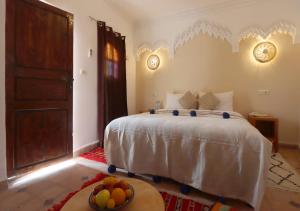 una camera da letto con un letto e un cesto di frutta sul pavimento di Riad Makech a Marrakech