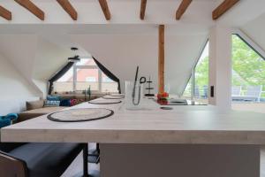 eine Küche mit einer großen weißen Theke in einem Zimmer mit Fenstern in der Unterkunft Neywatt 1 in Norderney