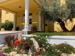 a yellow building with flowers in front of a yard at Villa Istriana in Ližnjan