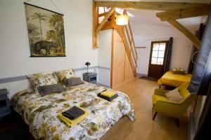 sypialnia z dużym łóżkiem i żółtym krzesłem w obiekcie Chambre d'hôtes, Aux Tuileries w mieście Noaillan