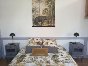 sypialnia z łóżkiem z 2 stolikami nocnymi i 2 lampami w obiekcie Chambre d'hôtes, Aux Tuileries w mieście Noaillan