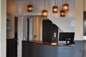 a kitchen with a counter with a television and pendant lights at Bude Hotel - An Mor in Bude