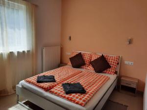 a bedroom with a bed with two black towels on it at Pension Horvath in Sankt Kanzian