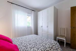 una camera bianca con un letto e una finestra di CasaPanda a Barbate