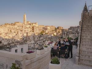 um grupo de pessoas sentadas em cadeiras em frente a uma cidade em Palazzo Degli Abati em Matera