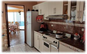 a kitchen with a stove and a refrigerator at Hostal Shalom in Pisco