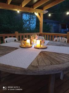 a wooden table with candles on a wooden deck at Dordogne Glamping in Bouzic