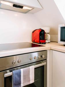 a kitchen with a stove top oven with a red appliance at Diófa Apartman in Keszthely