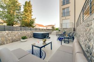 a patio with chairs and tables and a stone wall at Cosmopolitan Apartments in Krk