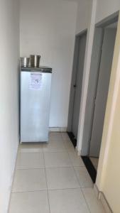 um corredor com um frigorífico num quarto em HOSTEL família QUARTO PRIVADO próximo aeroporto Int Guarulhos SP TÁXI 24 horas em Guarulhos