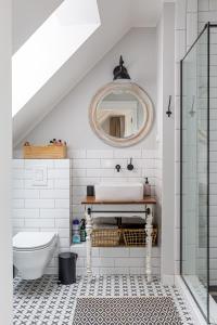 a white bathroom with a sink and a mirror at Apartament Bulvar Starówka in Elblag
