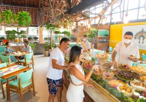 un grupo de personas comprando comida en un buffet en Hotel Village Porto De Galinhas, en Porto de Galinhas