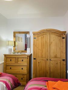 - une chambre avec un lit, une commode et un miroir dans l'établissement Arden Holiday Lettings, à Stratford-upon-Avon