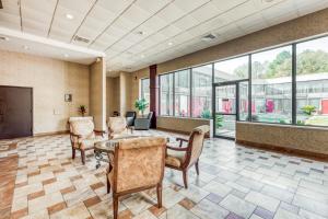 an office lobby with a table and chairs and windows at Capital O Nacogdoches - Hwy 59 & SW Stallings in Nacogdoches