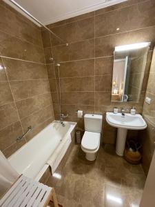 La salle de bains est pourvue de toilettes, d'un lavabo et d'une baignoire. dans l'établissement Luminoso apartamento en el centro de San Sebastián, à Saint-Sébastien