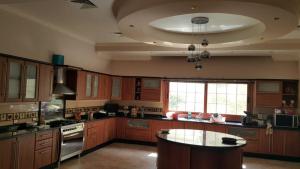 a large kitchen with wooden cabinets and a table at Super luxurious villa with large landscape areas in Cairo
