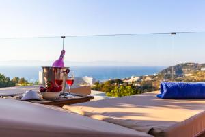 a table with a bottle of wine and a glass at FlyViewFlatsGOLD PrivateHotTub with SeaView in Rhodes Town