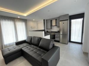 a living room with a couch and a kitchen at Apartamentos Cella in Cella