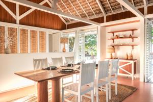 a dining room with a wooden table and chairs at Ananda Atins in Atins