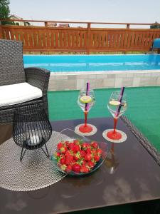 un tavolo con due bicchieri di vino e un cesto di frutta di Apartment Ferenac a Ozalj