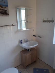 a bathroom with a sink and a mirror and a toilet at Ferienwohnungen Rügen-Glück in Lohme +13 photos