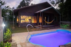 een groot zwembad in een achtertuin met een huis bij Casa Green Piccoli - Itajaí/SC in Itajaí