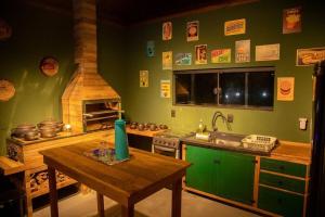 a kitchen with a stove and a sink and a table at Casa Green Piccoli - Itajaí/SC in Itajaí