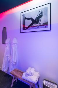une chambre avec un banc et une photo sur le mur dans l'établissement Art Déco Champagne & Spa, à Reims