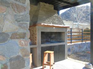 a stone oven with a wooden stool in front of it at Base Manzano in Tunuyán