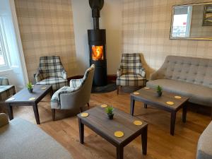 sala de estar con sofás y chimenea en Fife Lodge Hotel en Banff