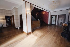 a living room with a wooden floor and a staircase at Fife Lodge Hotel in Banff