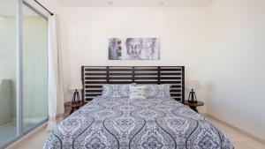 a bedroom with a bed with a blue and white comforter at Encanto Living Penthouse by Kivoya in Puerto Pe&ntilde;asco