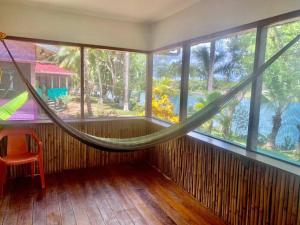 a room with a hammock in a room with windows at River Bend Resort Bze in Belize City