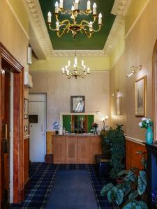 a large lobby with a chandelier and a desk at Rosehall Hotel in Edinburgh