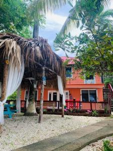 a building with a straw hut in front of a house at River Bend Resort Bze in Belize City
