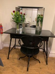 a black desk with a chair and a mirror at Central Whitby Seaglass studio in Whitby