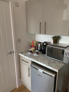 a kitchen with a counter top with a microwave at Central Whitby Seaglass studio in Whitby