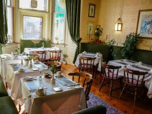 un ristorante con tavoli e sedie in una stanza di Rosehall Hotel a Edimburgo